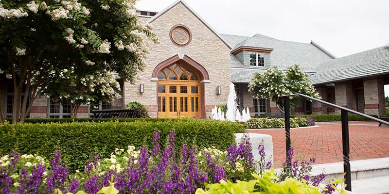 Entrance to the Brickman Center showcasing summer flowers and the fountain